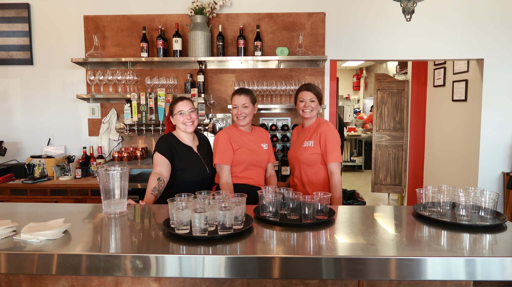 People posing at a restaurant counter