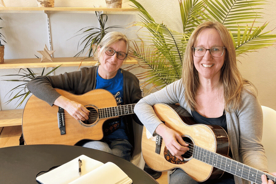 Lanesboro songwriters smiling and holding guitars