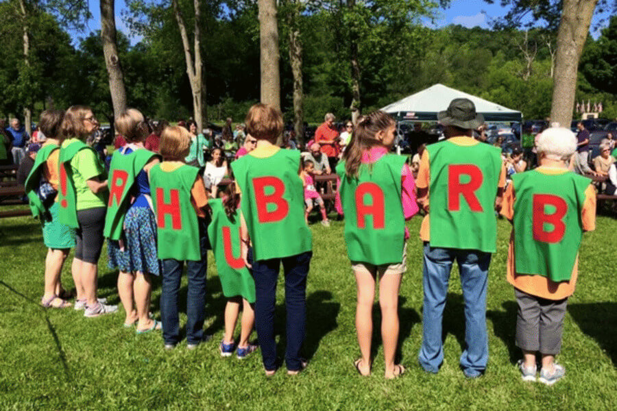 People standing in a line wearing shirts that spell out the letters to the word Rhubarb