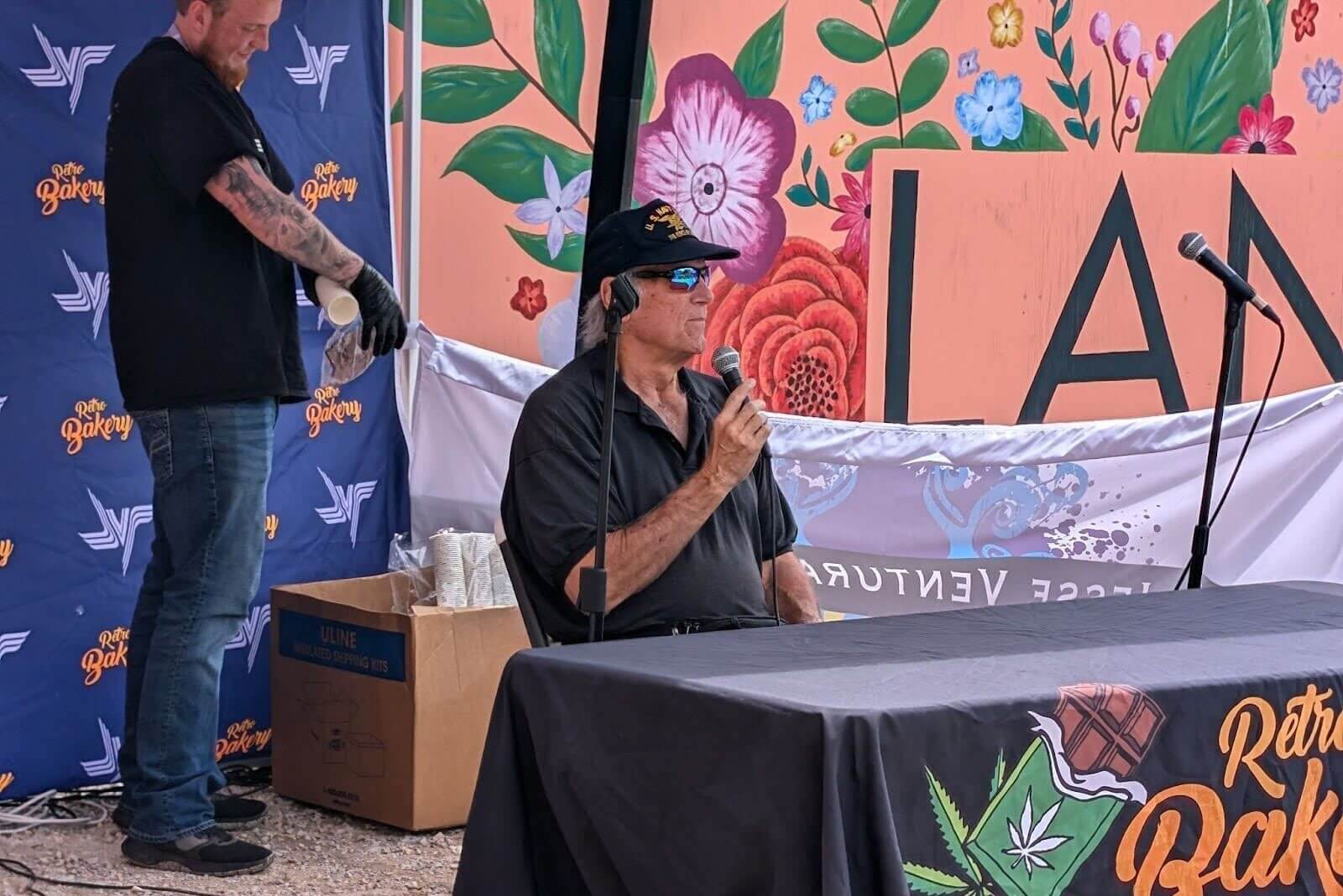 Jesse Ventura speaking on a microphone in Lanesboro, MN