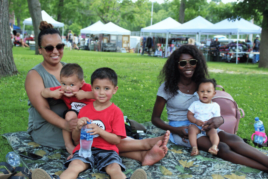 Two women and three children sit in Sylvan Park during Buffalo Bills Days