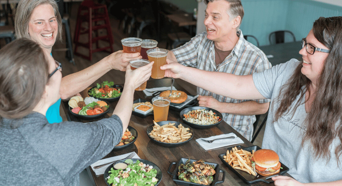 People sitting around a table enjoying food and beverages at Pedal Pusher's Cafe in Lanesboro, MN