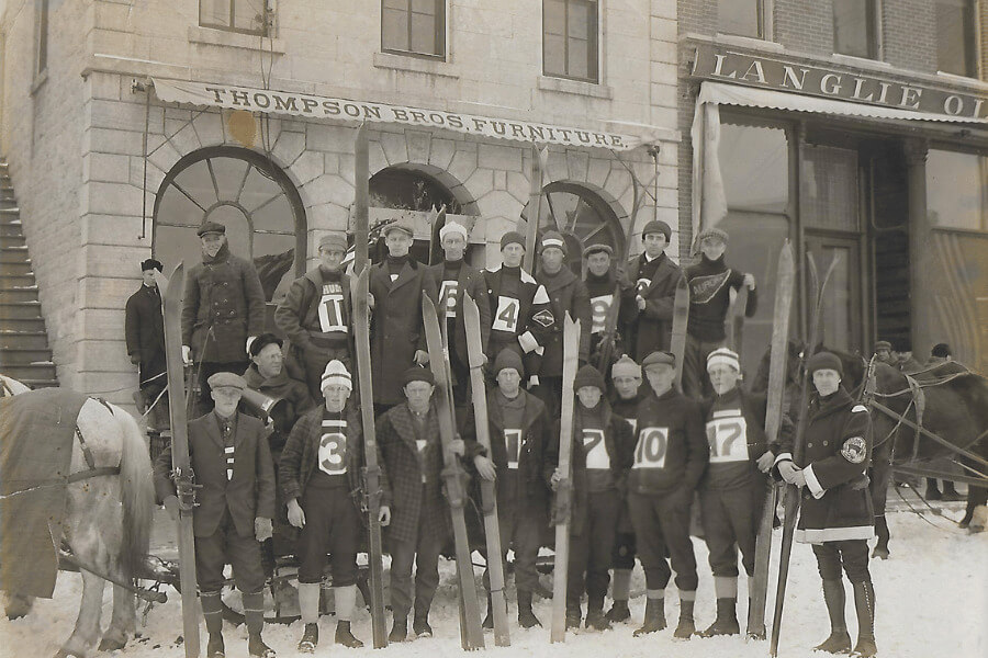 Historical photo of Lanesboro Ski Club members in front of the Thompson Bros. Furniture Store.