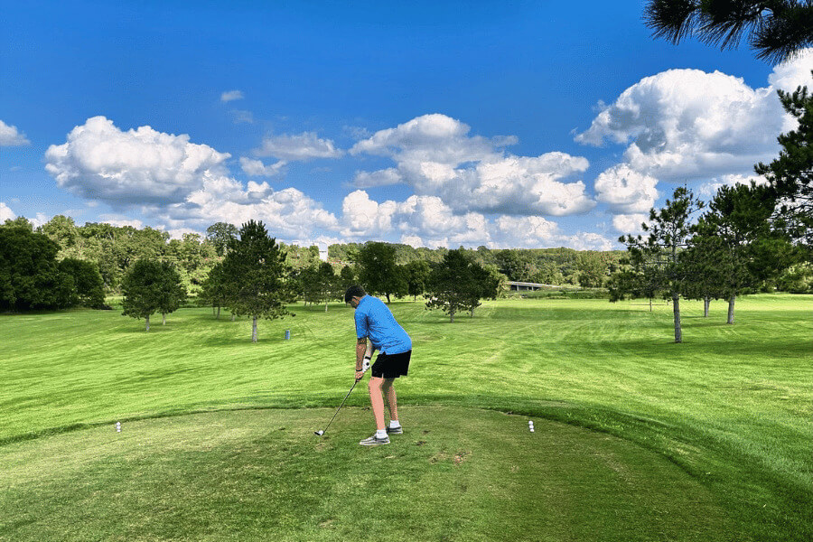 A man golfing at River's Bend Golf Course at Old Barn Resort.