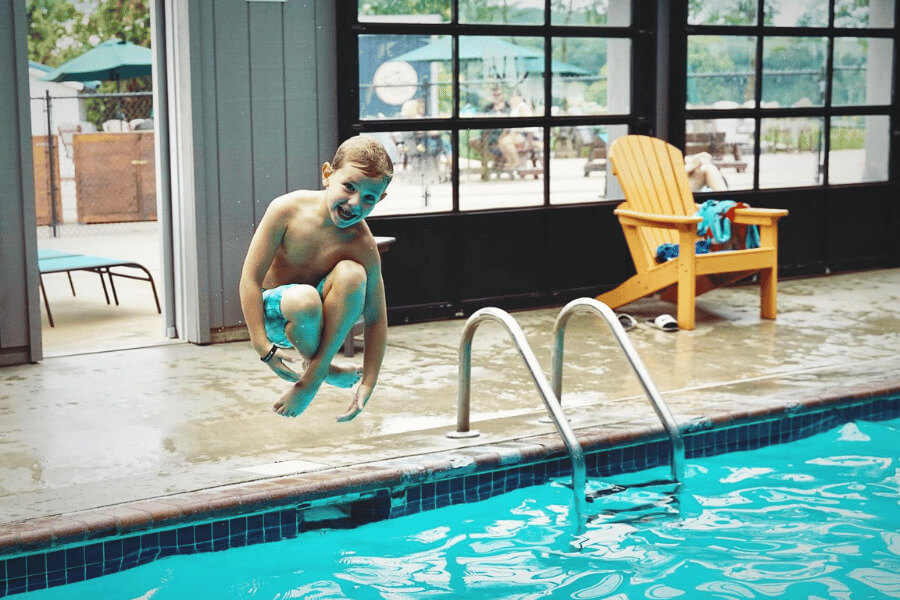 A child doing a cannonball at the pool