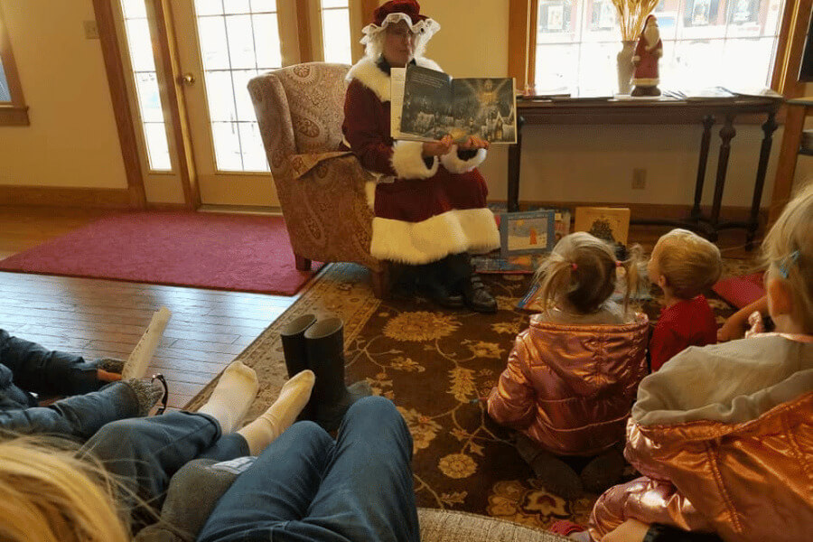 Inn owner Marti Gray dressed as Mrs. Claus reading holiday stories to children.