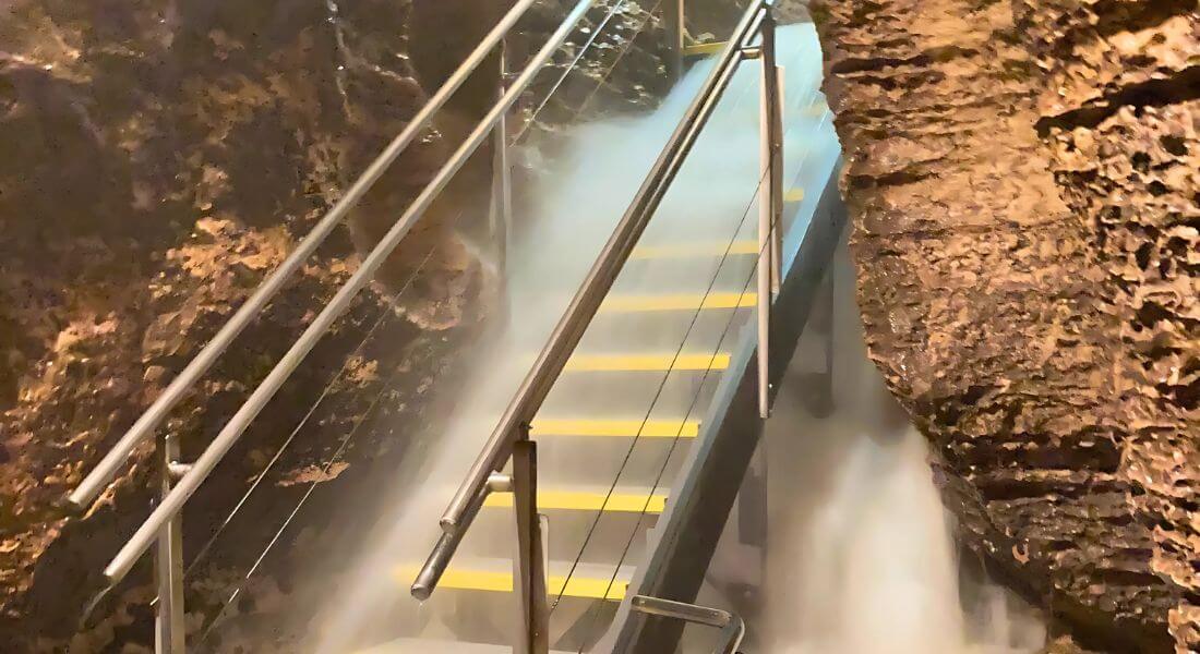 Stairway inside Niagara Cave surrounded by rushing floodwater after heavy rainfall