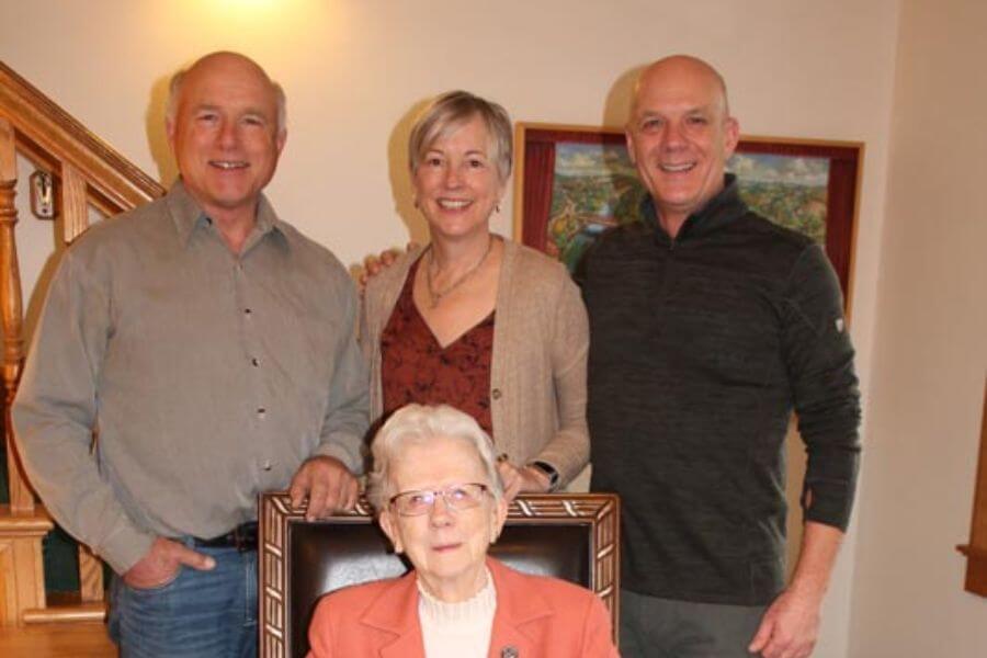 The Bunge family, founders and operators of The Cottage House Inn in Lanesboro, Minnesota, smiling together indoors with matriarch Marilyn Bunge seated in front.