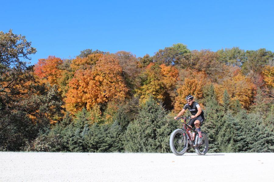 A cyclist rides along a gravel road surrounded by brilliant fall foliage near Lanesboro, Minnesota, during the Filthy 50 Gravel Bike Race.