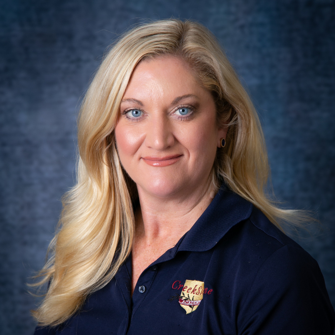 Woman wearing a navy blue polo against a blue background