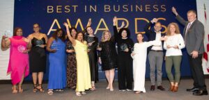 winners of the 2025 Best in Business Awards lined up on stage with their awards