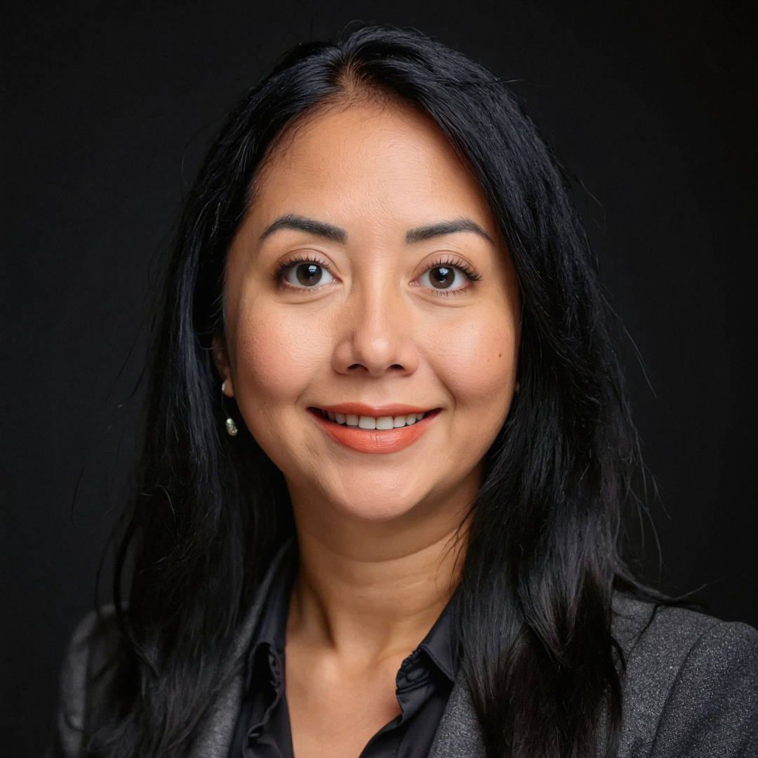 woman smiling with black hair, a black blazer, against a black background