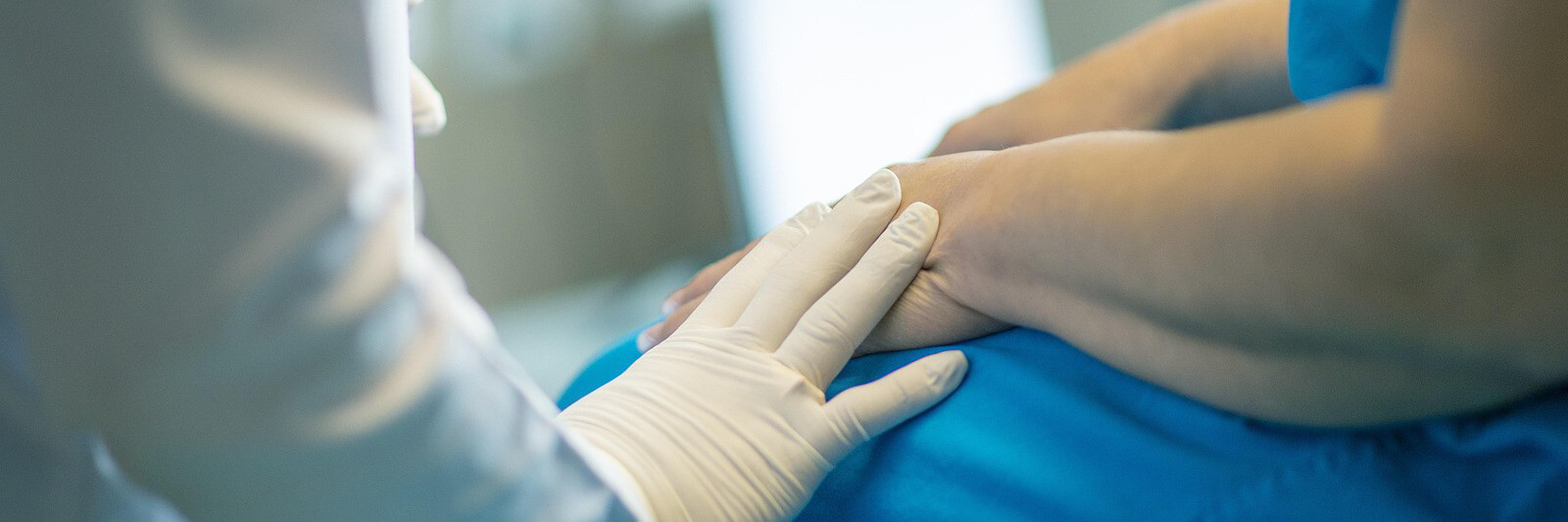 Caring doctor hand on patient hand