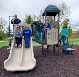 five adults on plastic playground equipment