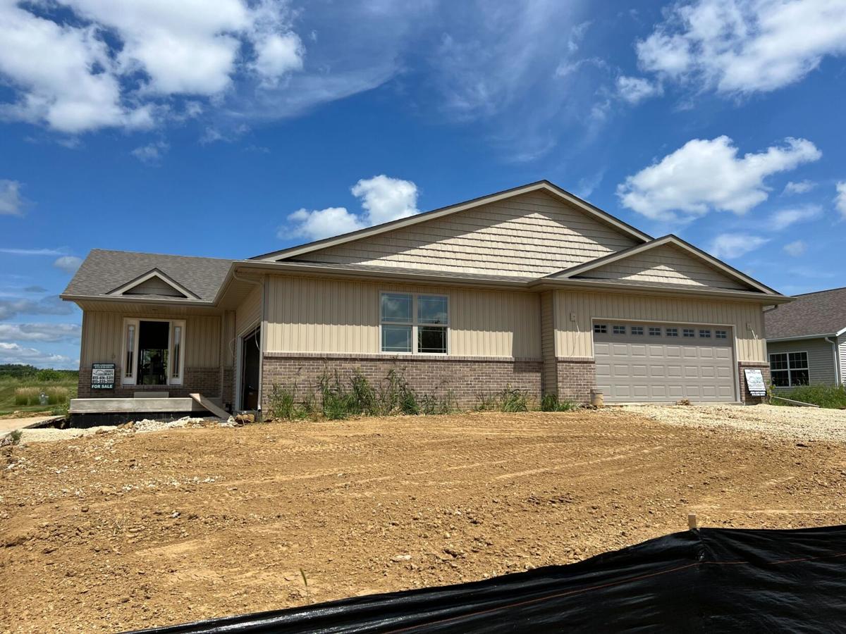 single story house. brown with brick front. dirt landscape