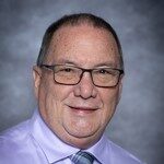 middle age man, glasses, purple button up shirt with tie