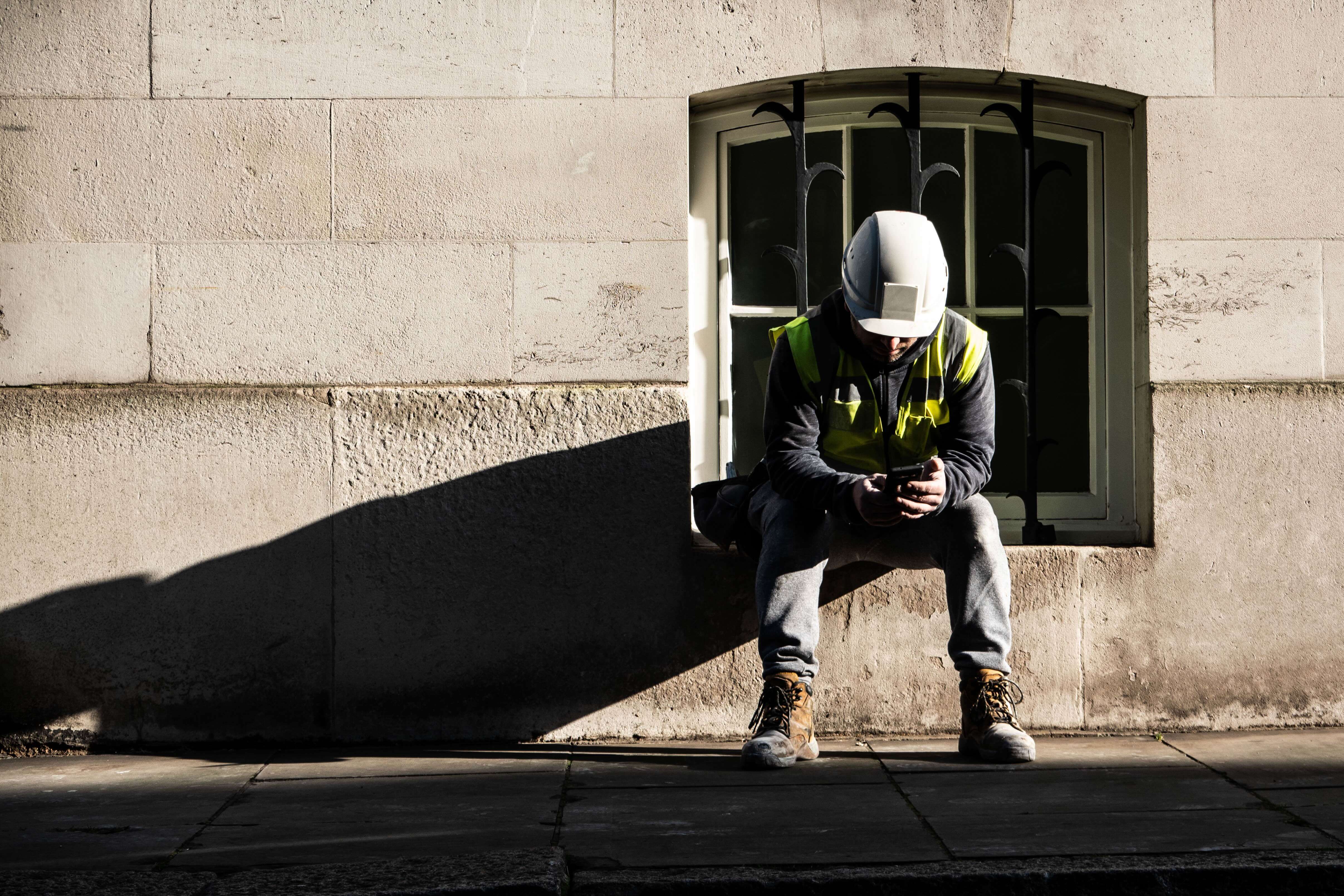 Construction Worker Builder Having a Break on Phone