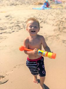 Smiling Child On Beach Watergun