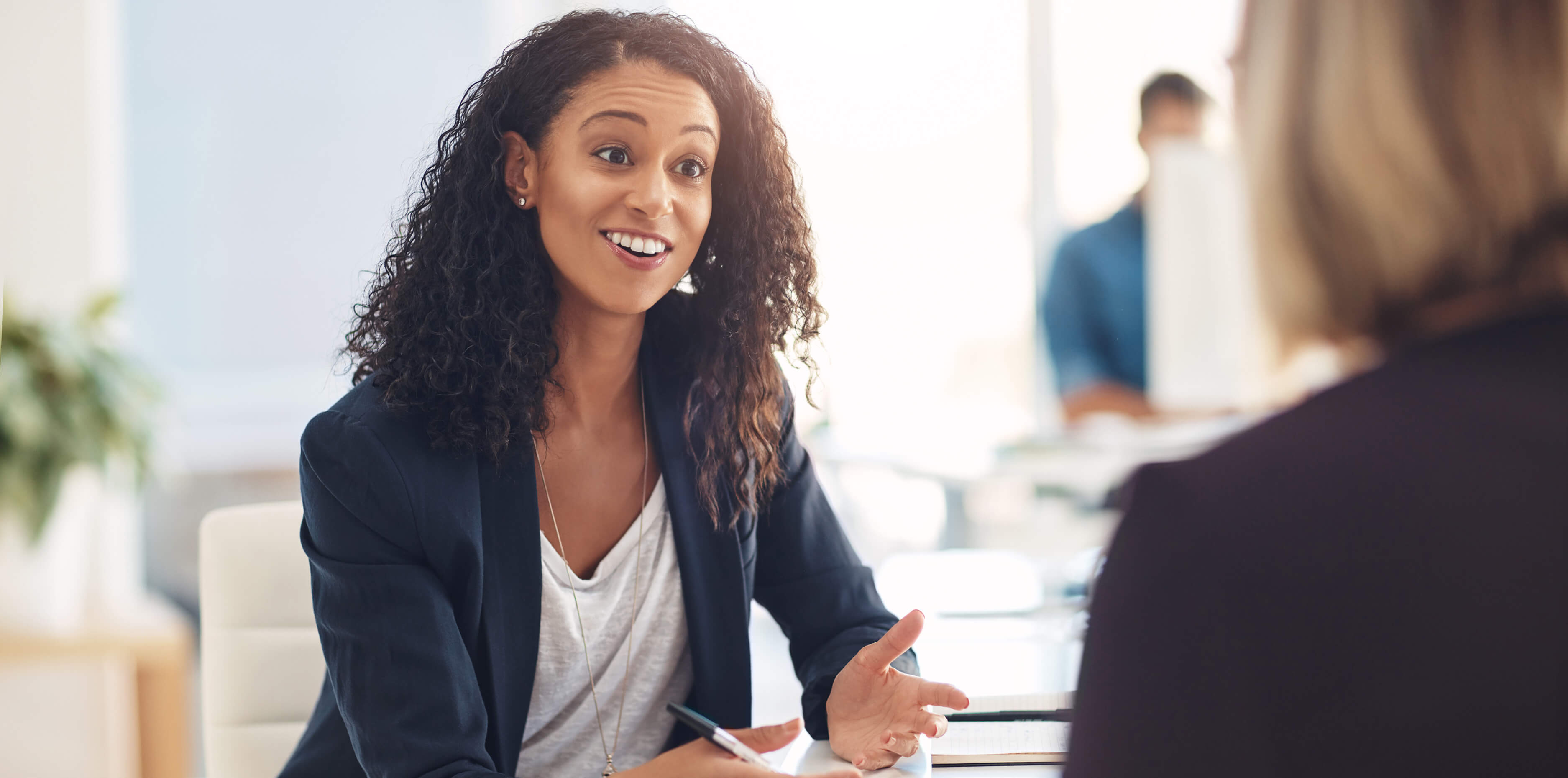 Interview with a happy, excited and confident human resources manager talking to a shortlist candidate for a job. Young business woman meeting with a colleague or coworker in her office at work.