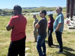 Group standing listening to instructions outside in field (no audio)