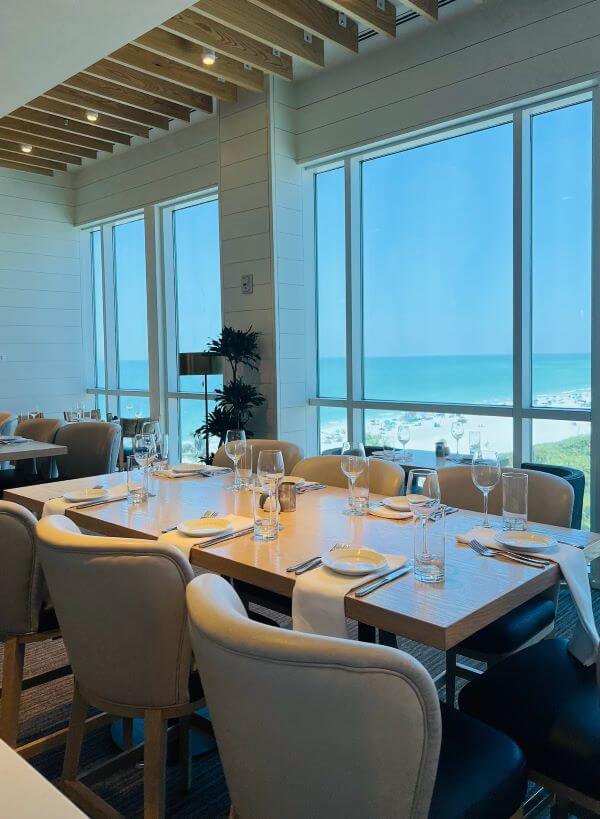 Dining table facing the window with a beach view.