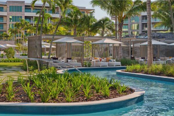 Photo of the pools and cabanas at the St. Regis Resort on Longboat Key. Beautfiful greenery around the pool and a lazy river.