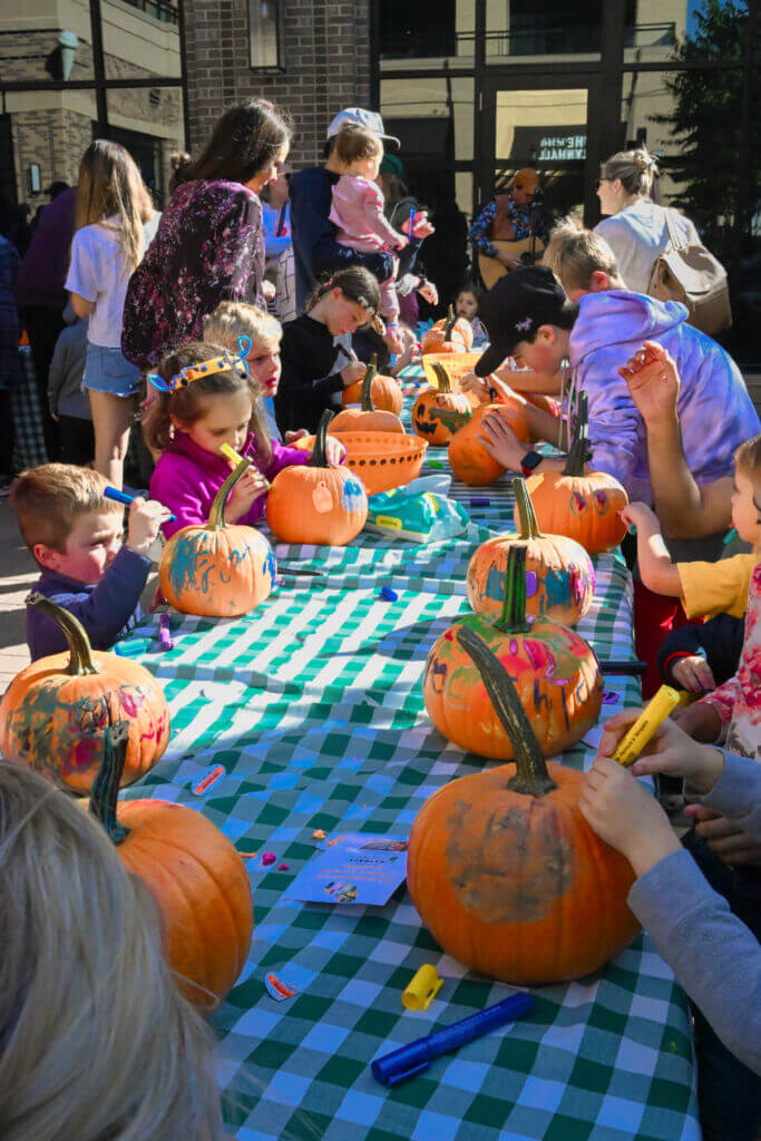 Kids painting pumpkins on the plaza