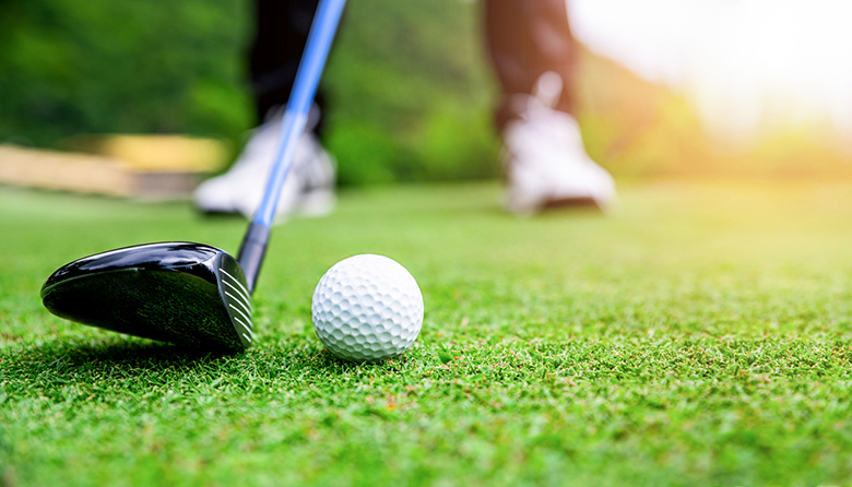 Close up golf ball on green grass field. sport golf club