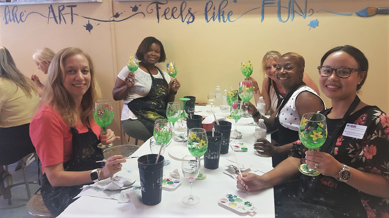 EMCCC Women’s Group enjoys painting wine glasses at Painting With a Twist Jenkintown at a summer networking event.