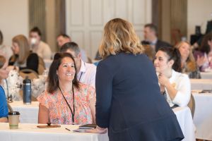 woman speaking to a table people seated at a table