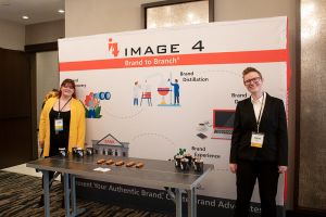 two people standing in front of a brand branch sign