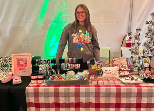 young girl selling items at market