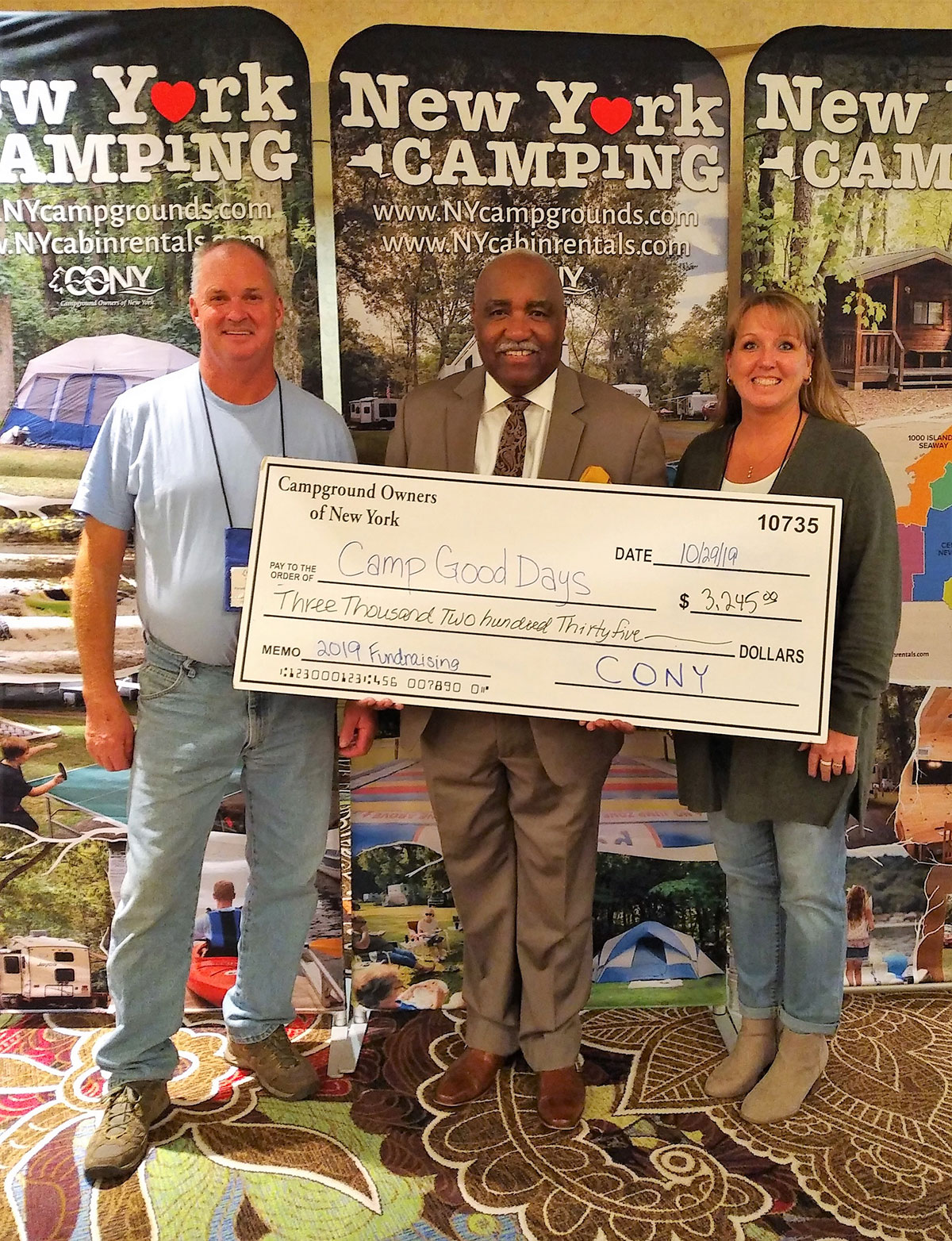 Campground owners pose with Camp Good Days rep and oversize check