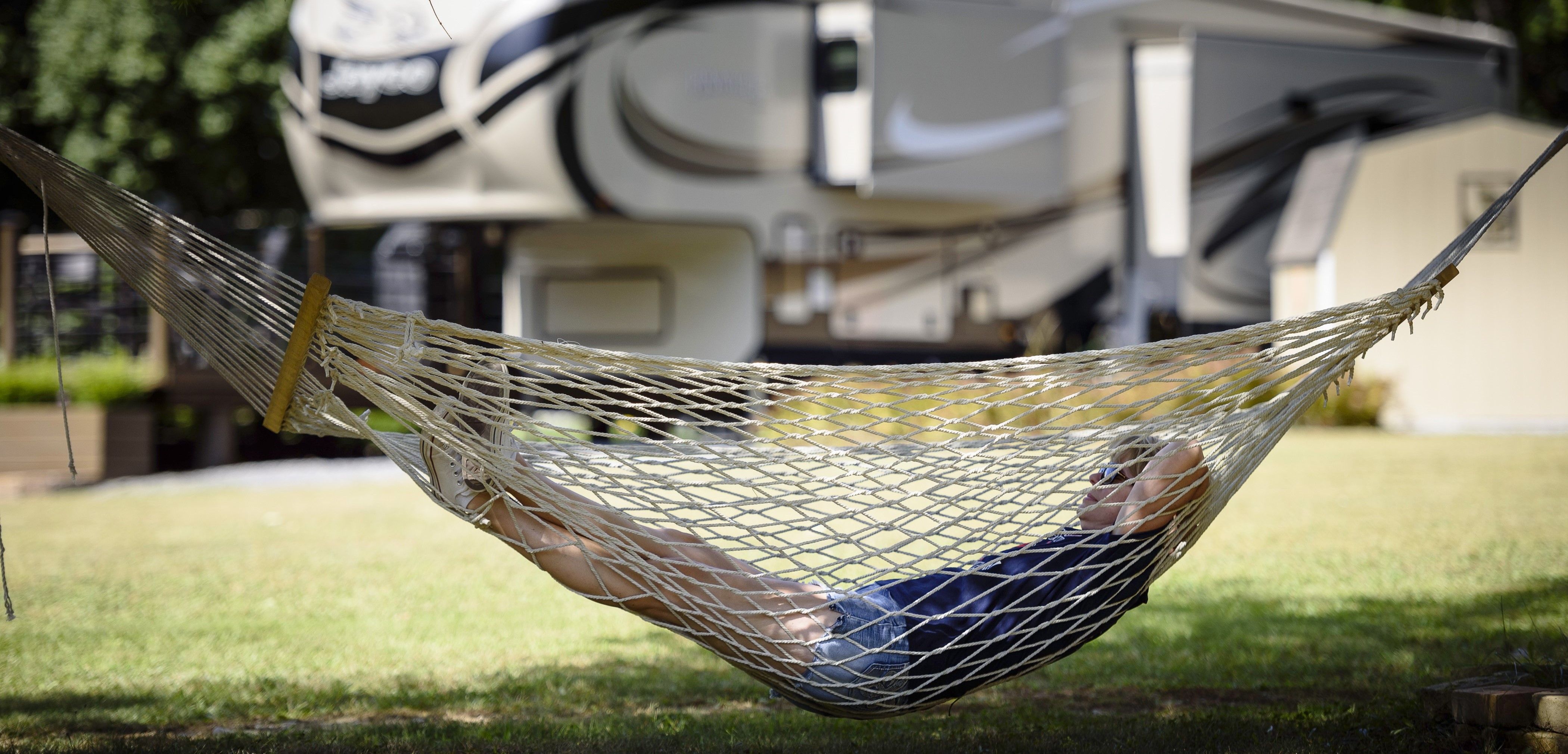 A woman relaxes in a hammock, surrounded by lush greenery, enjoying a peaceful moment in nature.