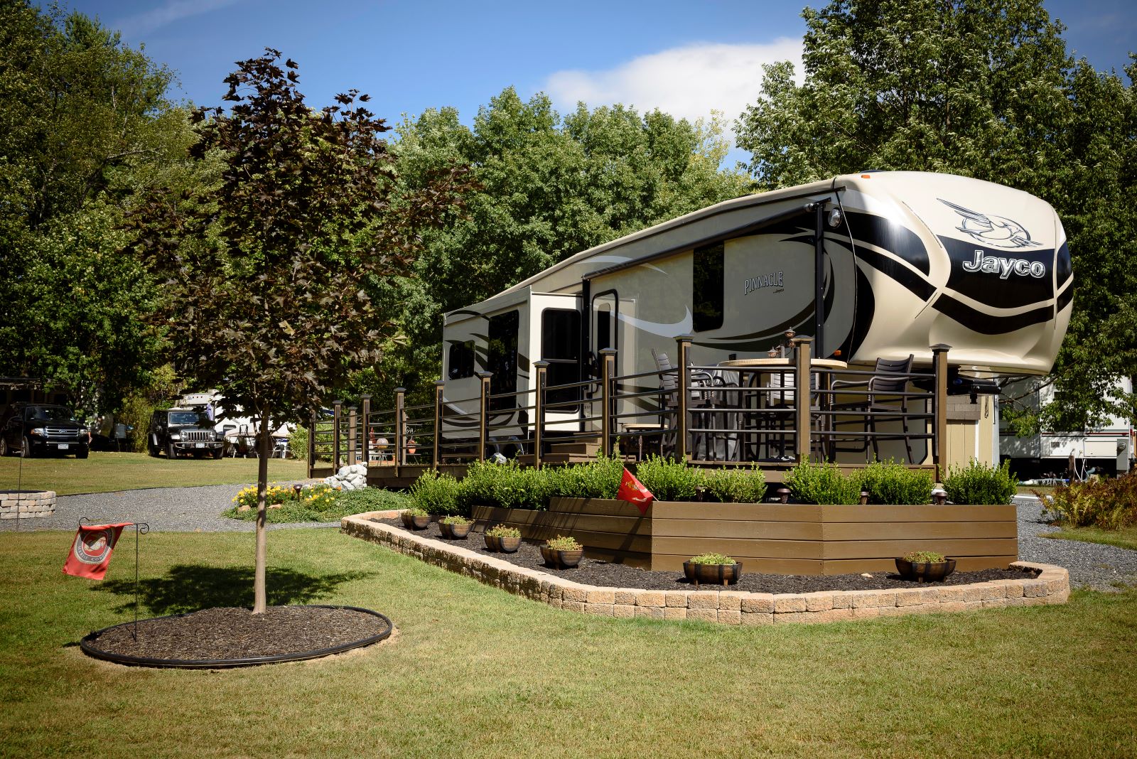 An RV park scene showcasing a tree and a small garden, providing a tranquil spot for visitors to unwind.