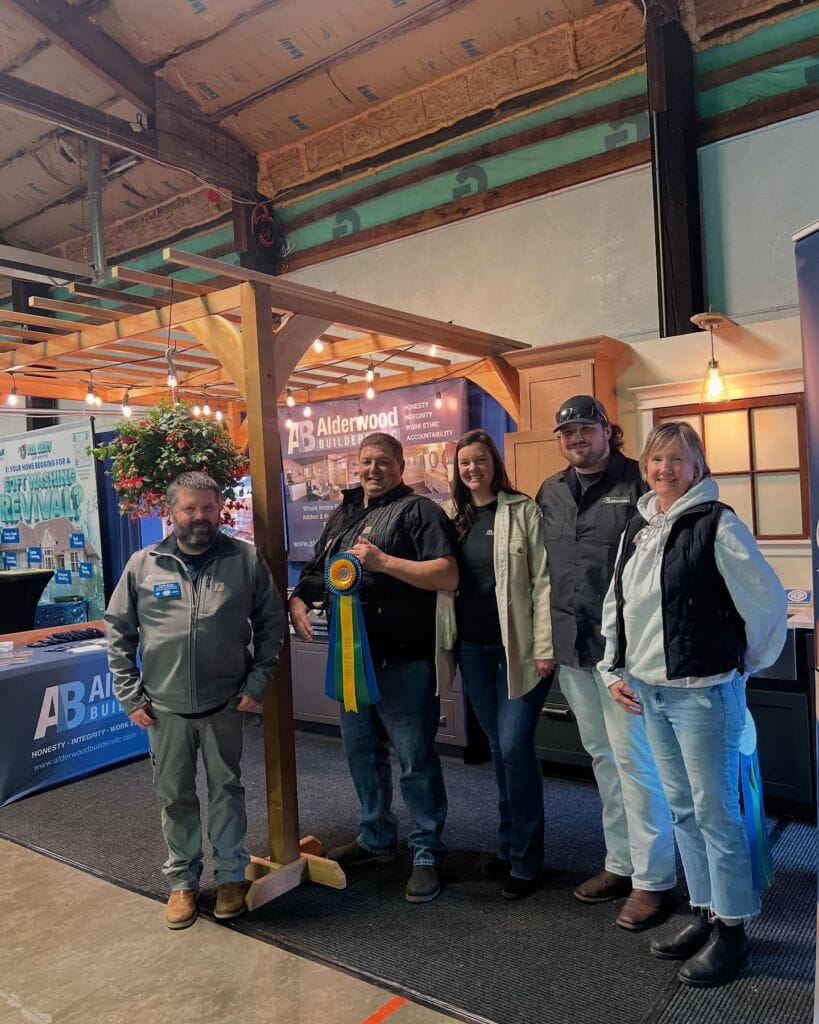 alderwood-builders-award-sicba-home-show-skagit-county-fairgrounds Alderwood Builders team receiving a ribbon award at the SICBA Home Show at the Skagit County Fairgrounds in Mount Vernon, WA