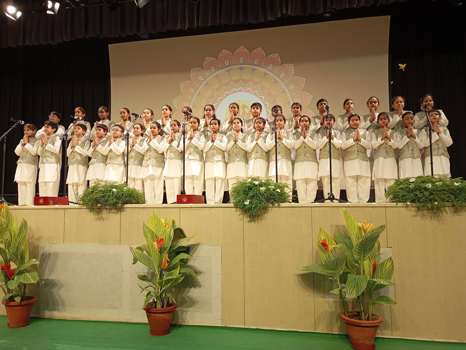 A group of children singing on a stage.