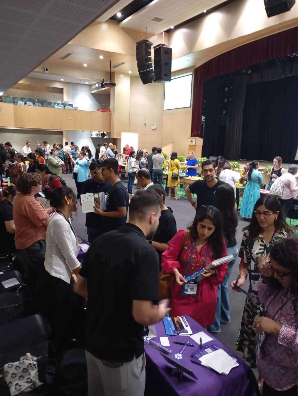 Students and parents conversing with university representatives.