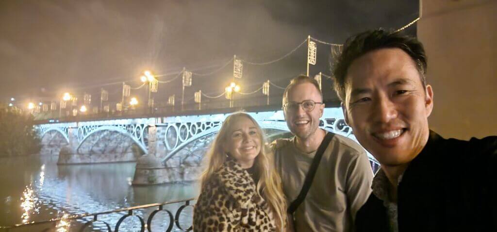 Three people in front of a bridge