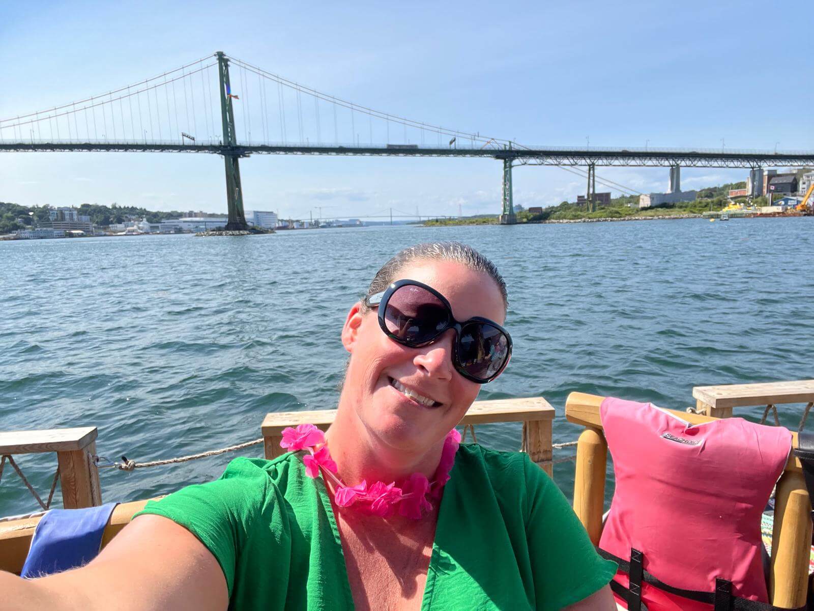 Woman taking a selfie on a tiki boat with a bridge in the background