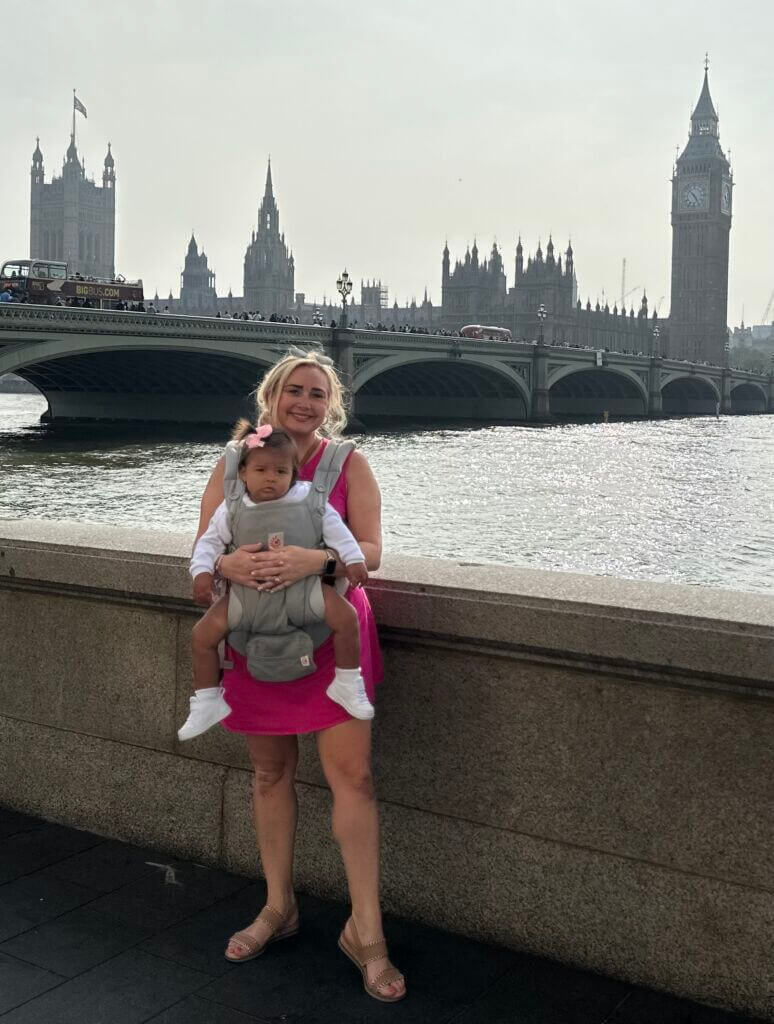 Margaret with her baby in front of the Westminster Bridge