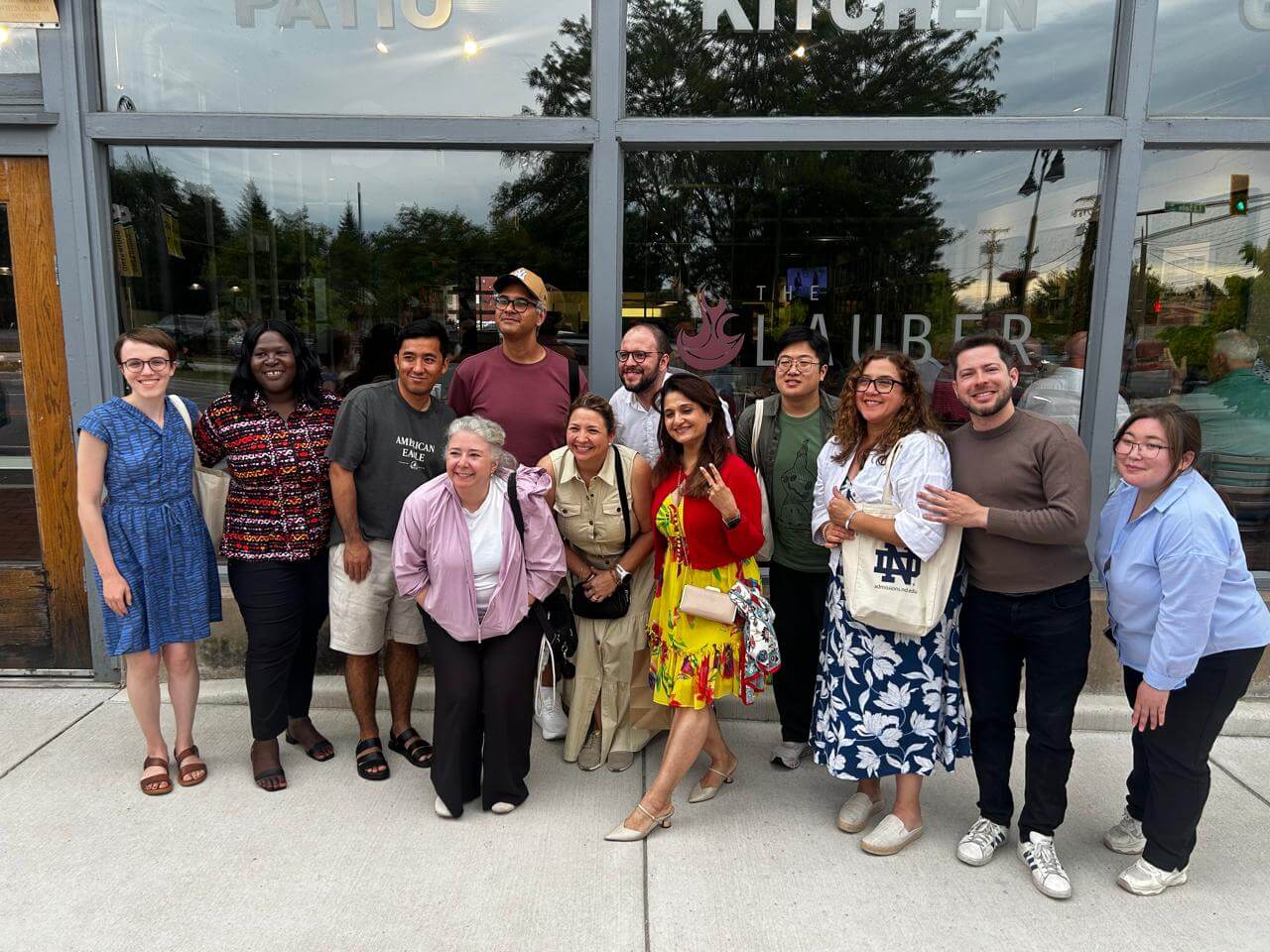 A group of people standing on a sidewalk together