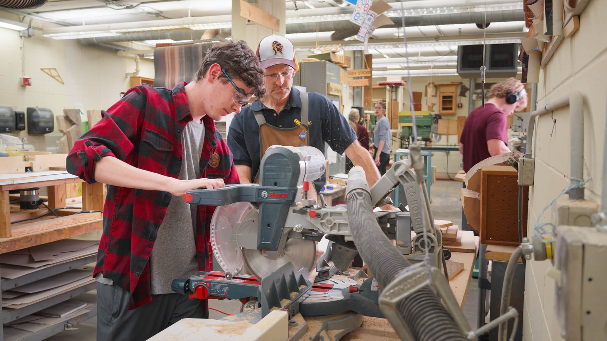 still from The Prodigy video showing two men operating a miter saw