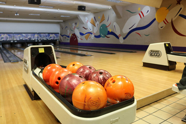 bowling balls on ball return at bowling alley
