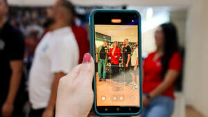 Person taking a photo of attendees gathered at a Greater Chamber of Harlingen event, capturing the energy and connections of business networking in Harlingen TX.