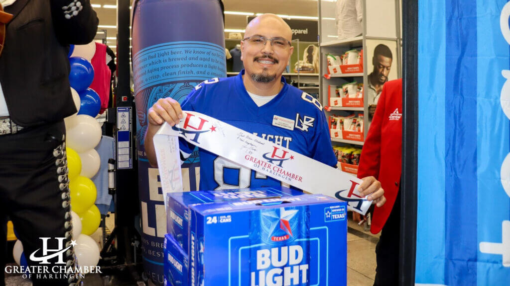 Person holding a ribbon with the Greater Chamber of Harlingen