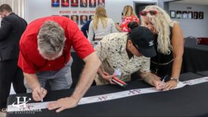 People signing Greater Chamber of Harlingen ribbon for ribbon-cutting event