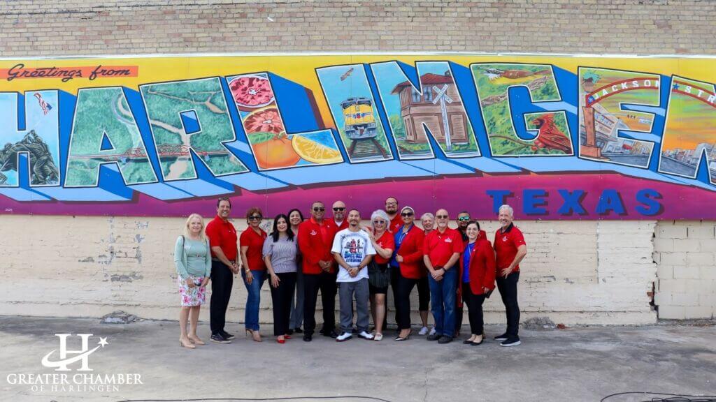 Community members admire a new mural by artist Adrian Rodriguez in Downtown Harlingen, featuring bold colors, local history, and iconic landmarks