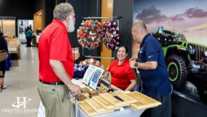 Community members and car enthusiasts gather to celebrate the ribbon cutting and grand opening of Bert Ogden Chrysler Dodge Ram Jeep, one of the many Harlingen companies, showcasing strong local support and community pride.