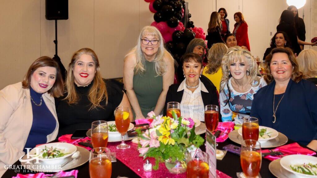attendees at the Annual Women EmPOWERment Night gathered around a table, highlighting community connection and local business support in Harlingen, Texas, with a focus on promoting local business support in Harlingen, Texas